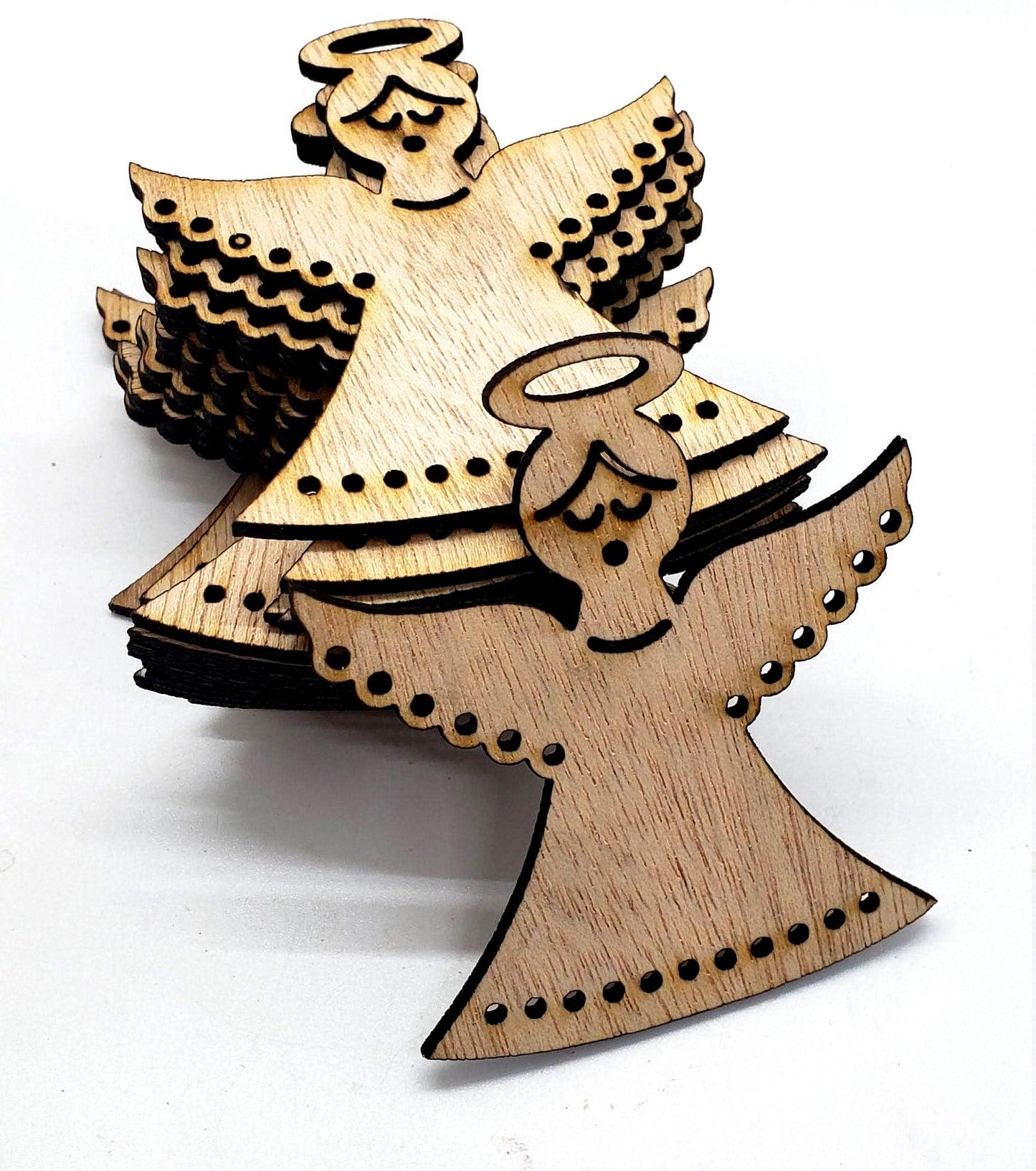 Gracefully carved with a minimalist elegance, this wooden angel radiates peace and holiday cheer. Her closed eyes and gentle smile evoke a sense of calm and quiet joy, while the halo above her head adds a touch of celestial reverence. Outstretched wings, adorned with circular cut-out patterns, frame her figure like a protective embrace. The robe flows downward in soft curves, echoing the wing motif with matching circular accents along the hem. Boldly etched across the bottom.