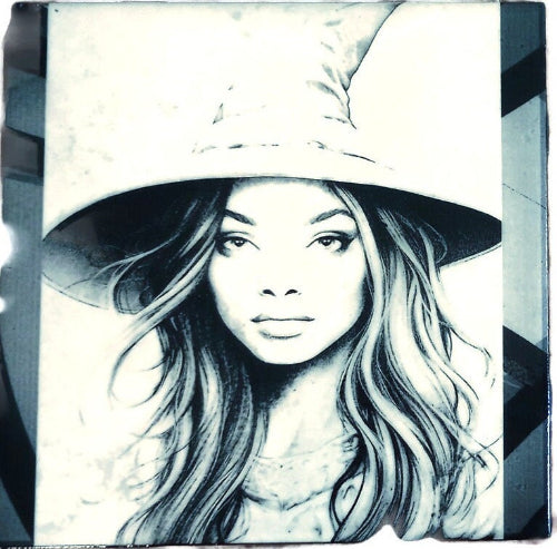 A timeless black and white portrait captures a woman adorned with a wide-brimmed hat. The image evokes a sense of mystery and classic elegance, with the stark contrast highlighting the intricate details of her attire and the play of light and shadow on her face. The hat, a defining feature, casts intriguing shadows, adding depth and intrigue to the composition, while the overall aesthetic speaks to vintage charm and enduring beauty.