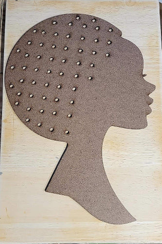 Silhouette of a head with textured hair on a wooden background. 