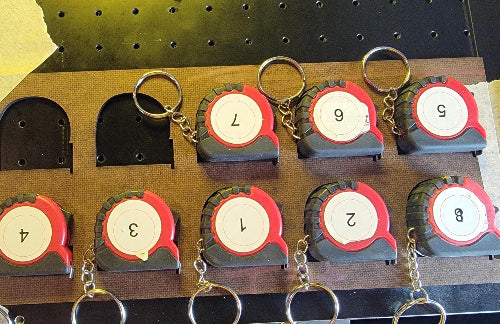 I used my laser to cut 1-inch removable sticky paper. Then I placed a sticker on each test run to check position. After the test, I simply pealed off the label.
DIGITAL FILE__Use the Mutoh 661 UV Printer and CompressRip setup to ensure that your mini tape measures are securely held during the printing and handling phases. For added protection, consider using a material that’s both ink and UV-resistant, like coated plywood or MDF with a protective finish.