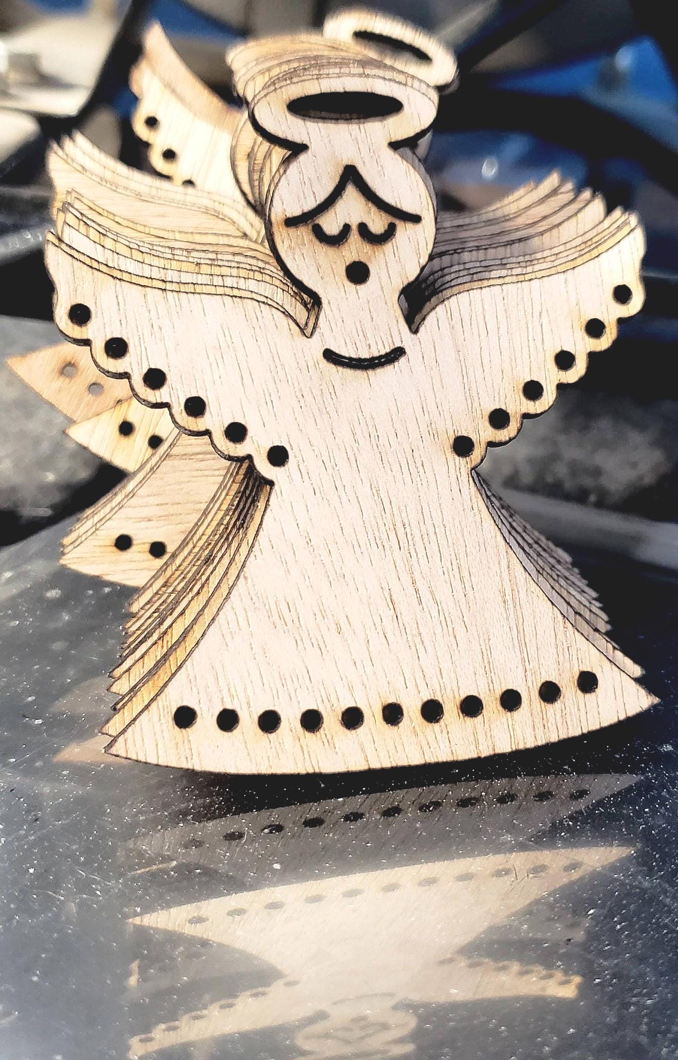 Gracefully carved with a minimalist elegance, this wooden angel radiates peace and holiday cheer. Her closed eyes and gentle smile evoke a sense of calm and quiet joy, while the halo above her head adds a touch of celestial reverence. Outstretched wings, adorned with circular cut-out patterns, frame her figure like a protective embrace. The robe flows downward in soft curves, echoing the wing motif with matching circular accents along the hem. Boldly etched across the bottom.