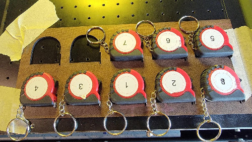 I used my laser to cut 1-inch removable sticky paper. Then I placed a sticker on each test run to check position. After the test, I simply pealed off the label.
DIGITAL FILE__Use the Mutoh 661 UV Printer and CompressRip setup to ensure that your mini tape measures are securely held during the printing and handling phases. For added protection, consider using a material that’s both ink and UV-resistant, like coated plywood or MDF with a protective finish.