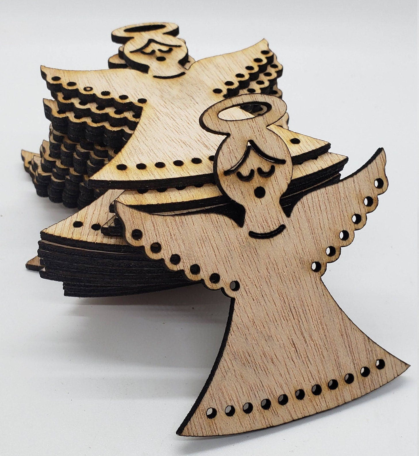 Wooden angel cutout with black accents on a white background